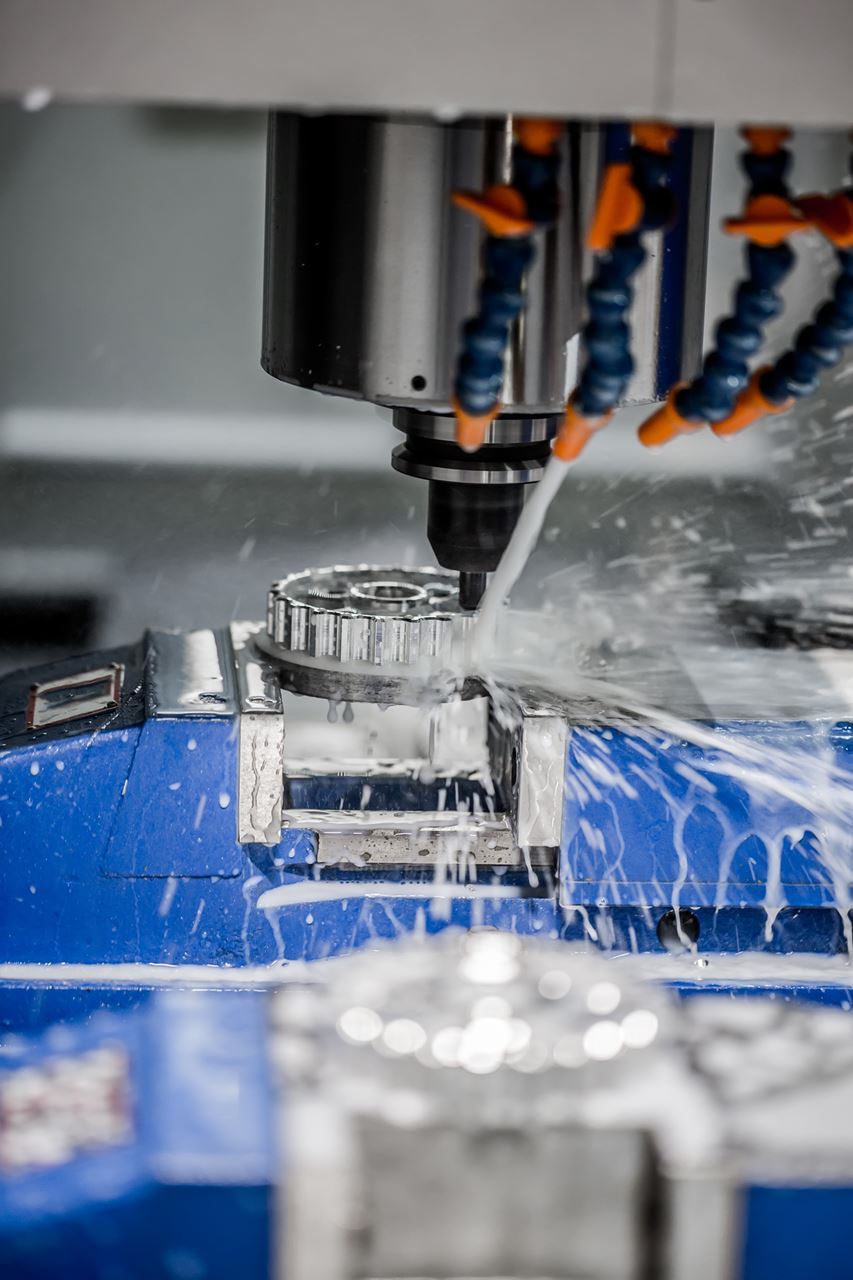 Image of a CNC machine spraying water or coolant while cutting metal